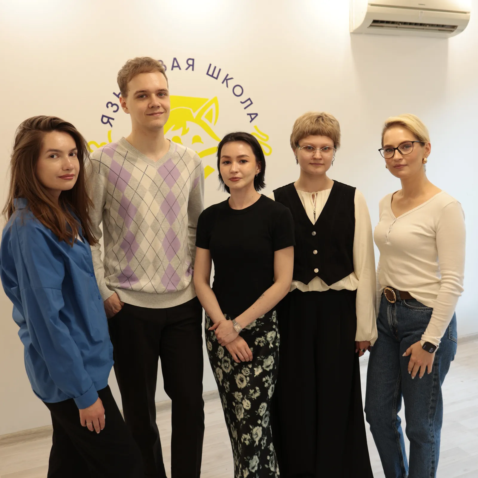 Команда школы Фоксинбург у фирменной стены с лисой