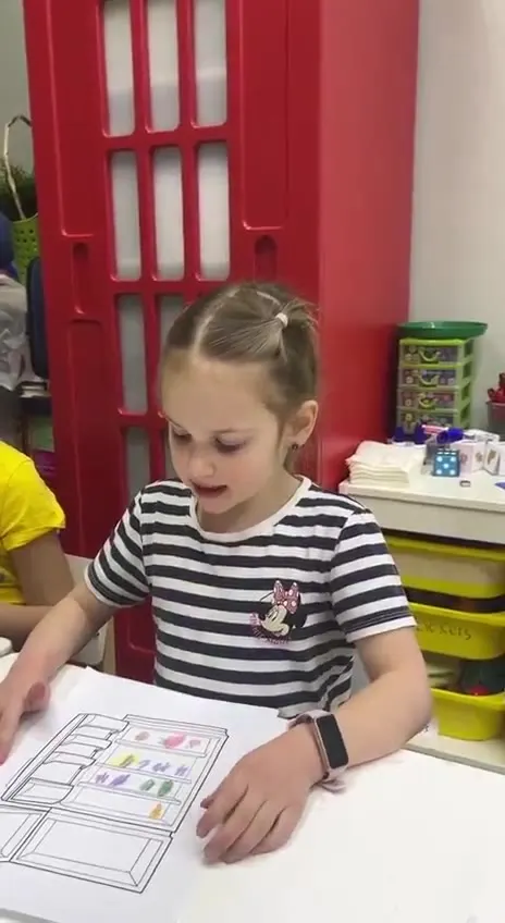 Девочка 5–6 лет выполняет задание в тетради