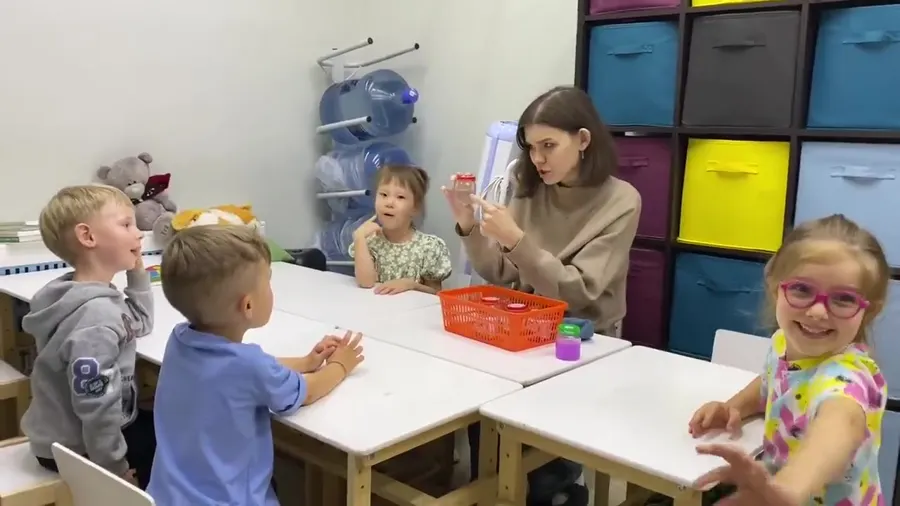 Педагог занимается с малышами за столом