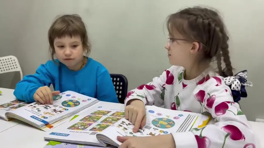 Малыши рассматривают книжку на занятии английским